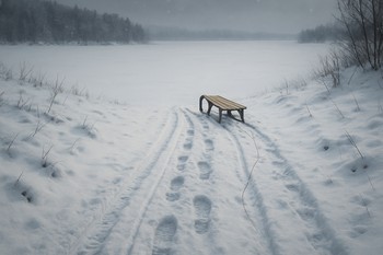 Следы от саней и ботинок тянутся по склону к замёрзшему озеру