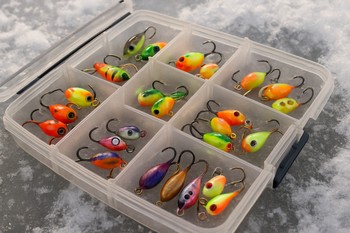 Коробка с приманками для подлёдной рыбалки лежит на льду