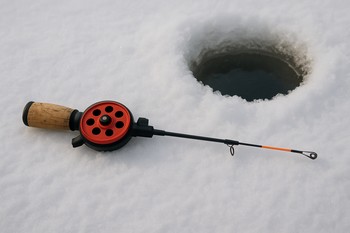 Удочка лежит на снегу рядом с лункой
