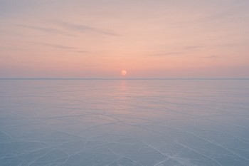 Мягкий закат отражается в гладком льду